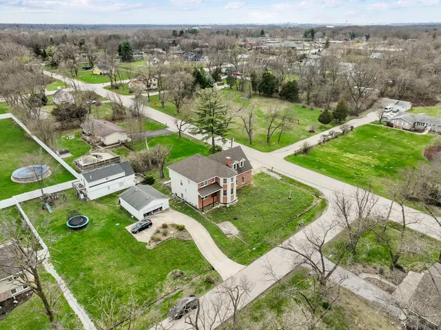 an aerial view of residential houses with outdoor space and trees