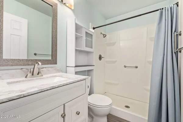 a bathroom with a granite countertop sink toilet and shower