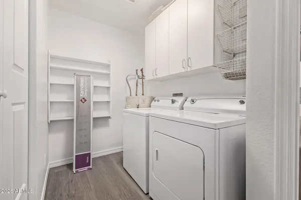 a utility room with cabinets washer and dryer