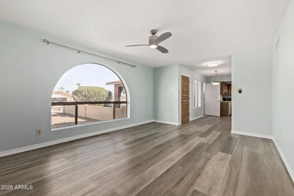 a view of an empty room with a window and wooden floor