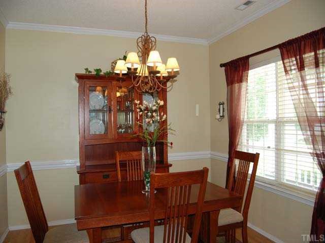 5608 Enoree Lane Raleigh, NC 27616 - Photo 3 of 12 The elegant dining room has an upgraded chandelier, laminate floor, painted chairrail and crown molding, double window with 22 blinds and arched doorways
