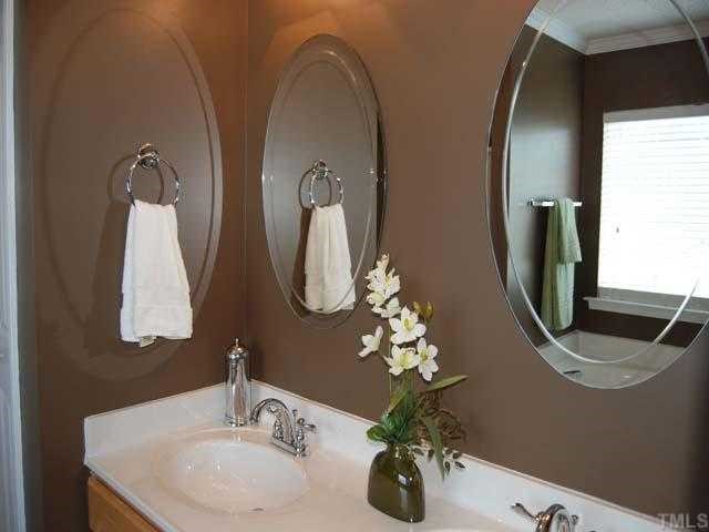 5608 Enoree Lane Raleigh, NC 27616 - Photo 7 of 12 An elegant master bath has cultured marble double sink with maple cabinets, two upgraded vanity lights, two mirrors, picture window with 22 blinds, garden tub, walk in shower, walk in closet, recessed light and a separate water closet