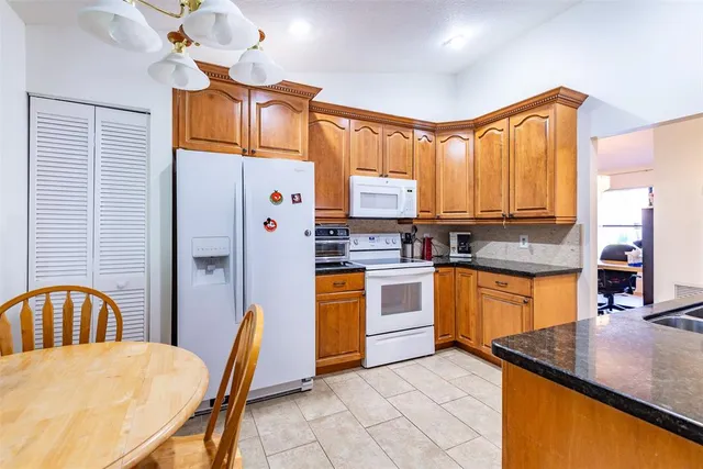 a kitchen with stainless steel appliances granite countertop a sink a stove and a refrigerator