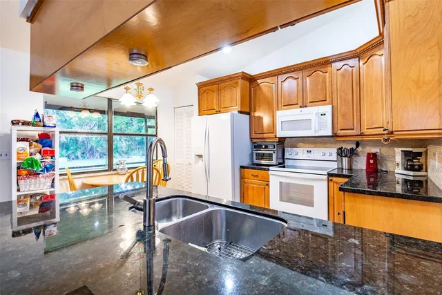 a kitchen with stainless steel appliances granite countertop a sink and cabinets