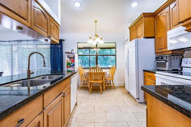 a kitchen with stainless steel appliances granite countertop a stove a sink and a refrigerator