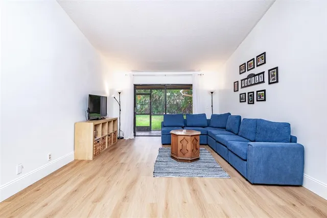 a kitchen with stainless steel appliances granite countertop a stove and a view of living room