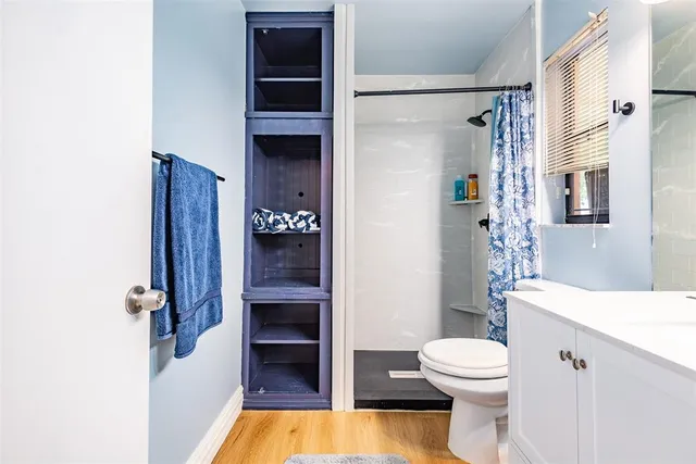 a bathroom with a sink a toilet and shower