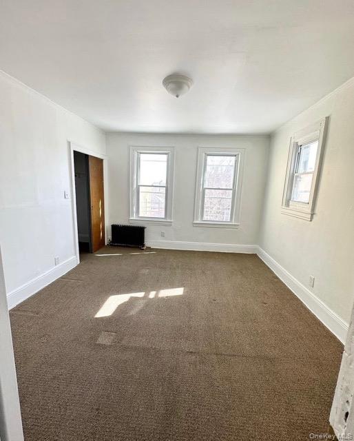 103-08 97th Avenue, Unit 2 Queens, NY 11416 - Photo 2 of 6 Spare room featuring carpet floors and radiator heating unit