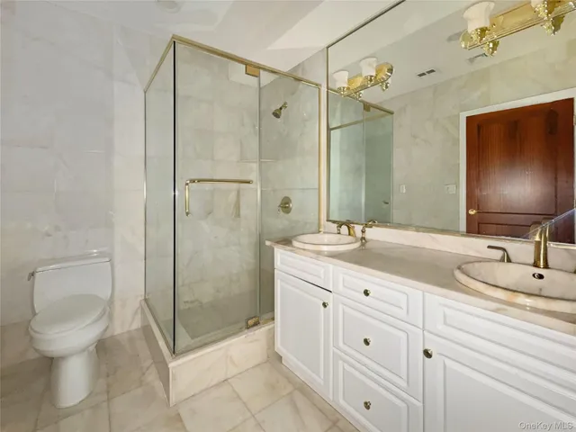 a bathroom with a double vanity sink toilet and shower