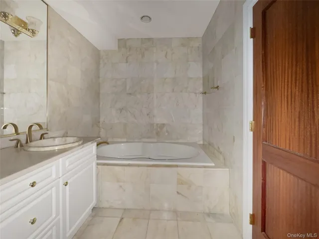 a bathroom with a granite countertop sink a mirror and a shower