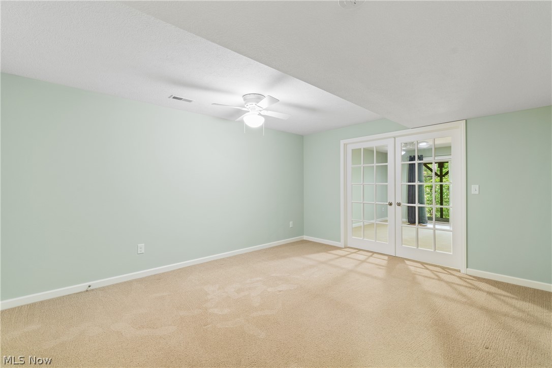 273 Stoner Road Clinton, OH 44216 - Photo 30 of 40 Additional bedroom, media room, or office in finished basement featuring carpet, ceiling fan, and french doors