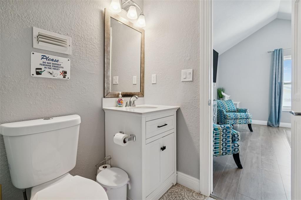 330 6th Avenue Indian Rocks Beach, FL 33785 - Photo 30 of 52 a bathroom with a toilet a sink and mirror