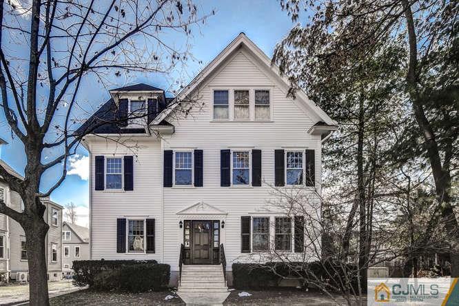 a front view of a house with a tree