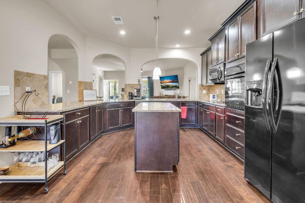 549 Harmony Way Locust Grove, GA 30248 - Photo 5 of 28 a kitchen with stainless steel appliances granite countertop wooden cabinets a sink dishwasher a stove and a refrigerator