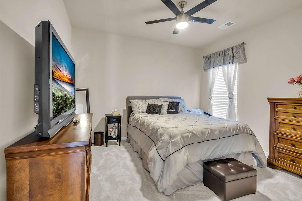 549 Harmony Way Locust Grove, GA 30248 - Photo 8 of 28 a bedroom with a bed and a flat screen tv