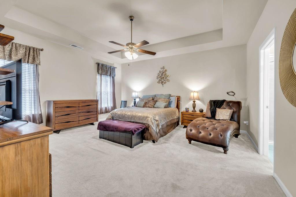 549 Harmony Way Locust Grove, GA 30248 - Photo 10 of 28 a spacious bedroom with a bed and a chandelier