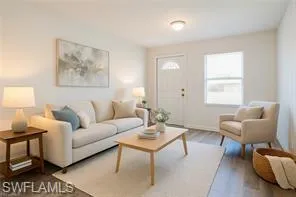 a living room with furniture a rug and a window