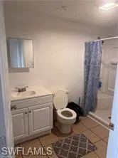 a bathroom with a granite countertop toilet and a sink