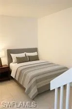 a bedroom with a bed and a night stand