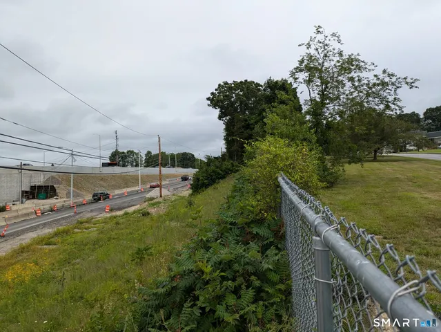 a view of a swimming pool with a yard and large trees