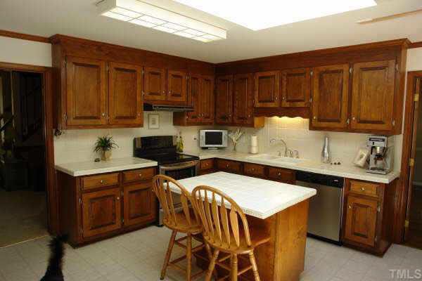 1201 Ravens Point Circle Raleigh, NC 27614 - Photo 3 of 8 a kitchen with stainless steel appliances a sink a stove a refrigerator cabinets and a dining table
