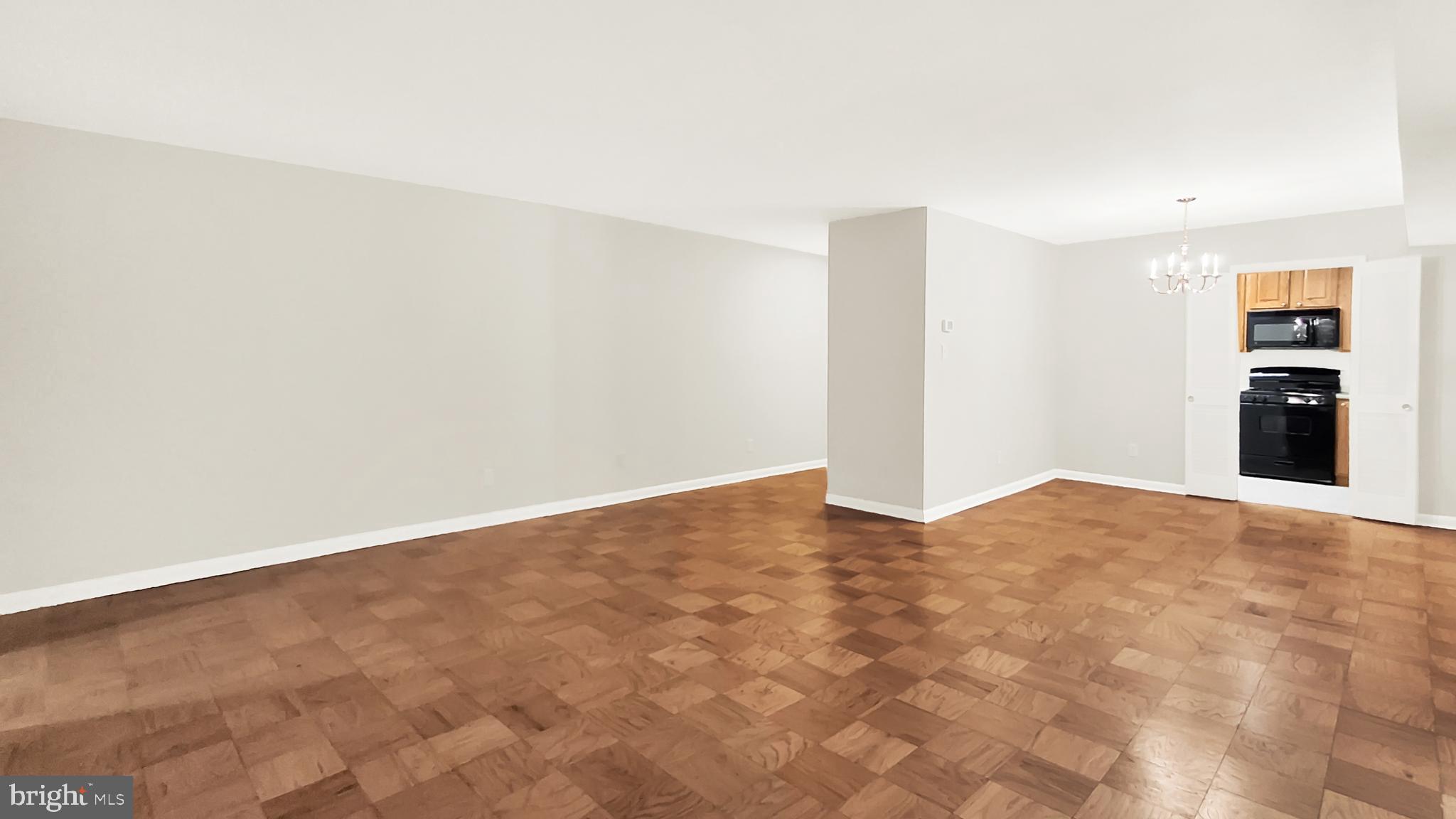 10655 Montrose Avenue, Unit 103 Bethesda, MD 20814 - Photo 16 of 26 a view of a livingroom with wooden floor and a staircase