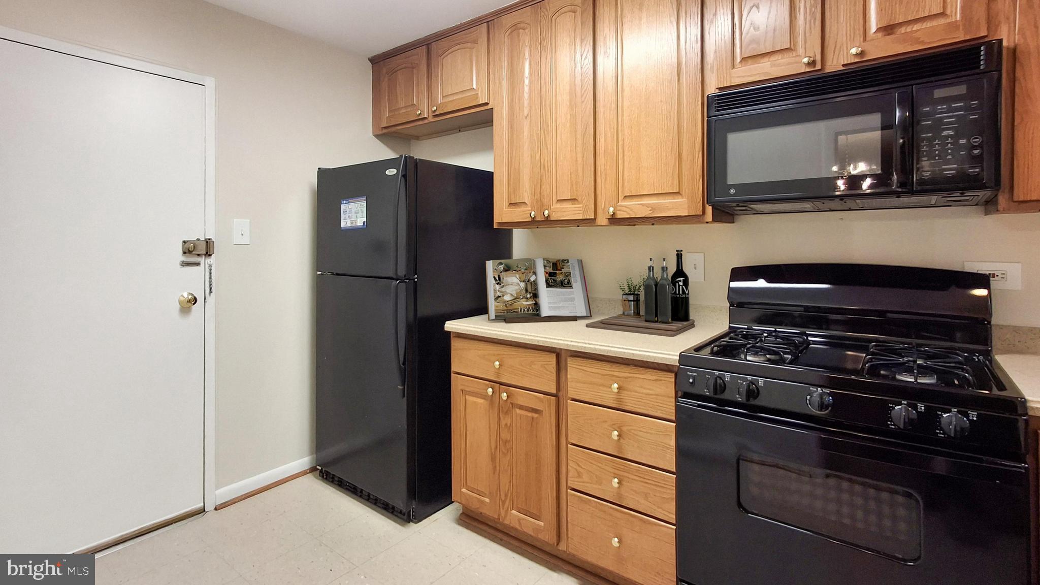 10655 Montrose Avenue, Unit 103 Bethesda, MD 20814 - Photo 3 of 26 a kitchen with a refrigerator stove and microwave