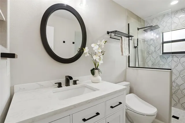 a bathroom with a sink a toilet and a mirror