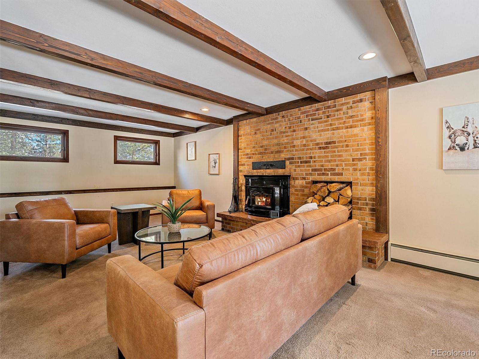 7990 Tim Tam Trail Evergreen, CO 80439 - Photo 16 of 45 a living room with furniture and a fireplace