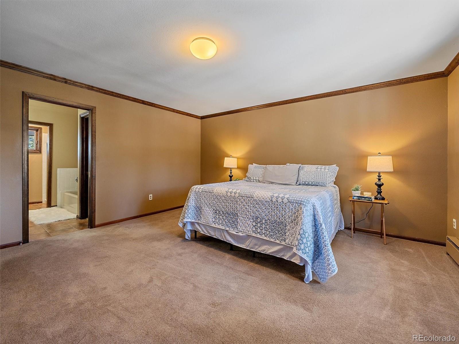 7990 Tim Tam Trail Evergreen, CO 80439 - Photo 20 of 45 a bedroom with a bed and a night stand