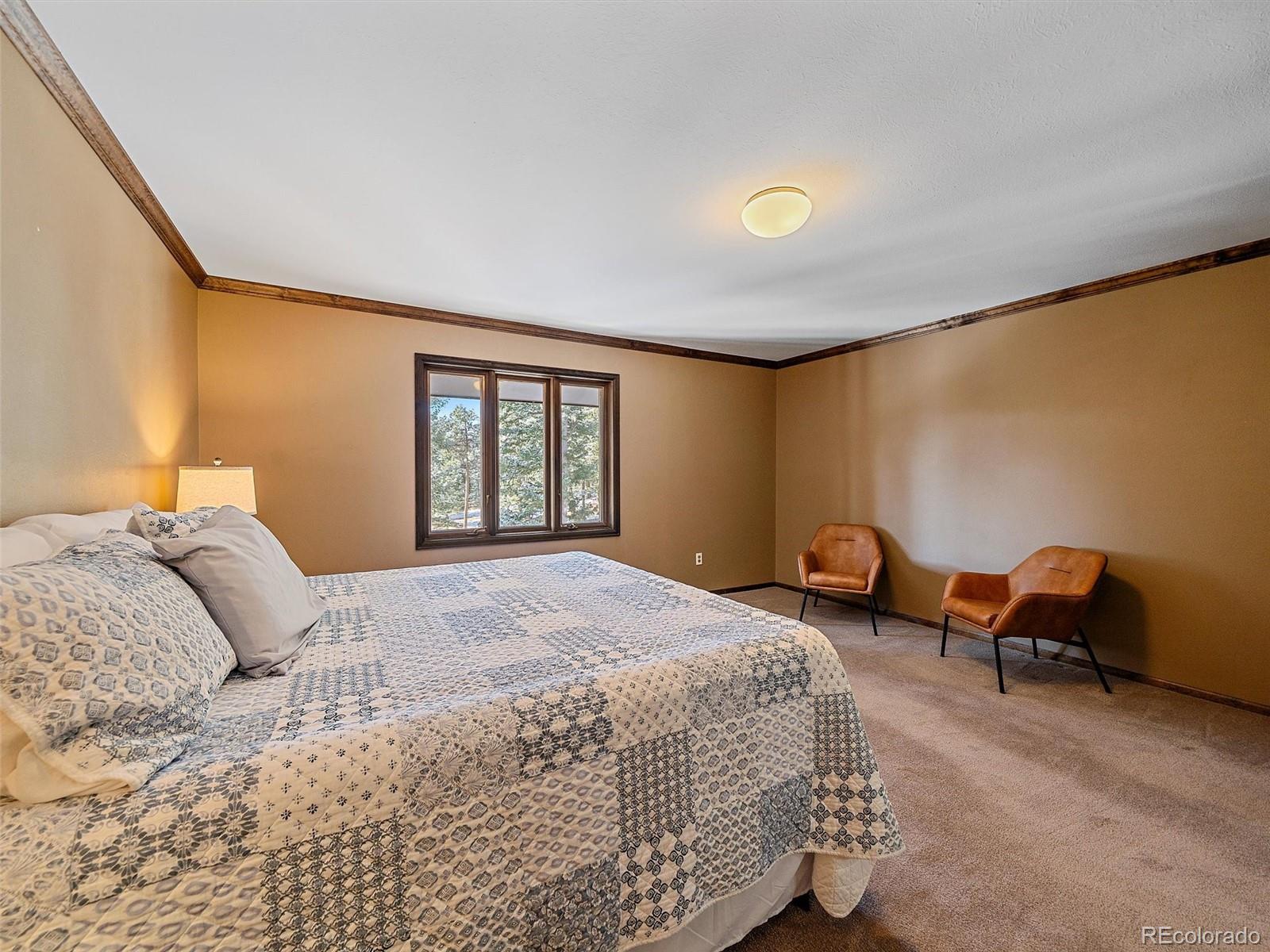 7990 Tim Tam Trail Evergreen, CO 80439 - Photo 25 of 45 a bedroom with a bed and a window