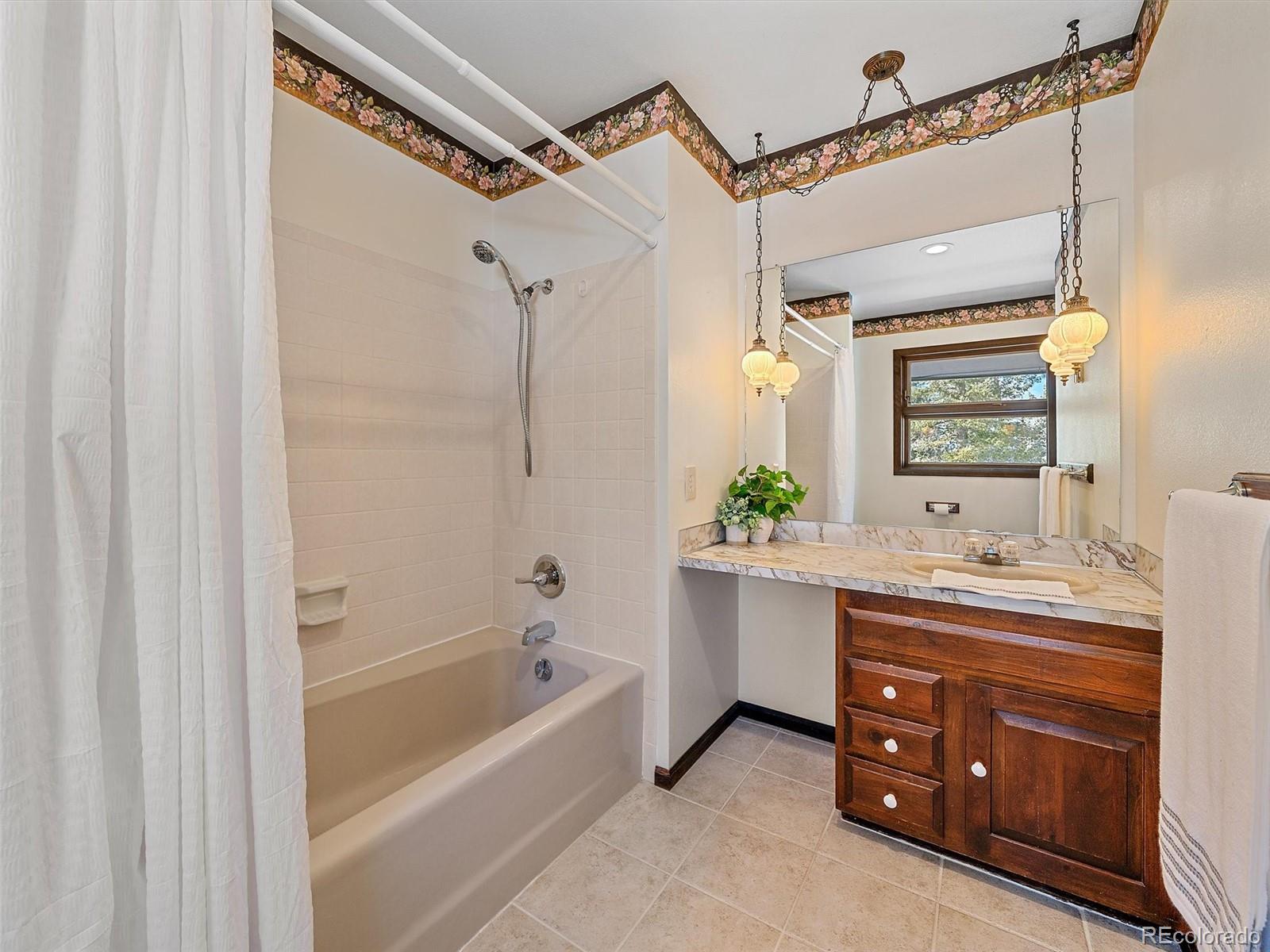 7990 Tim Tam Trail Evergreen, CO 80439 - Photo 26 of 45 a bathroom with a tub sink and mirror