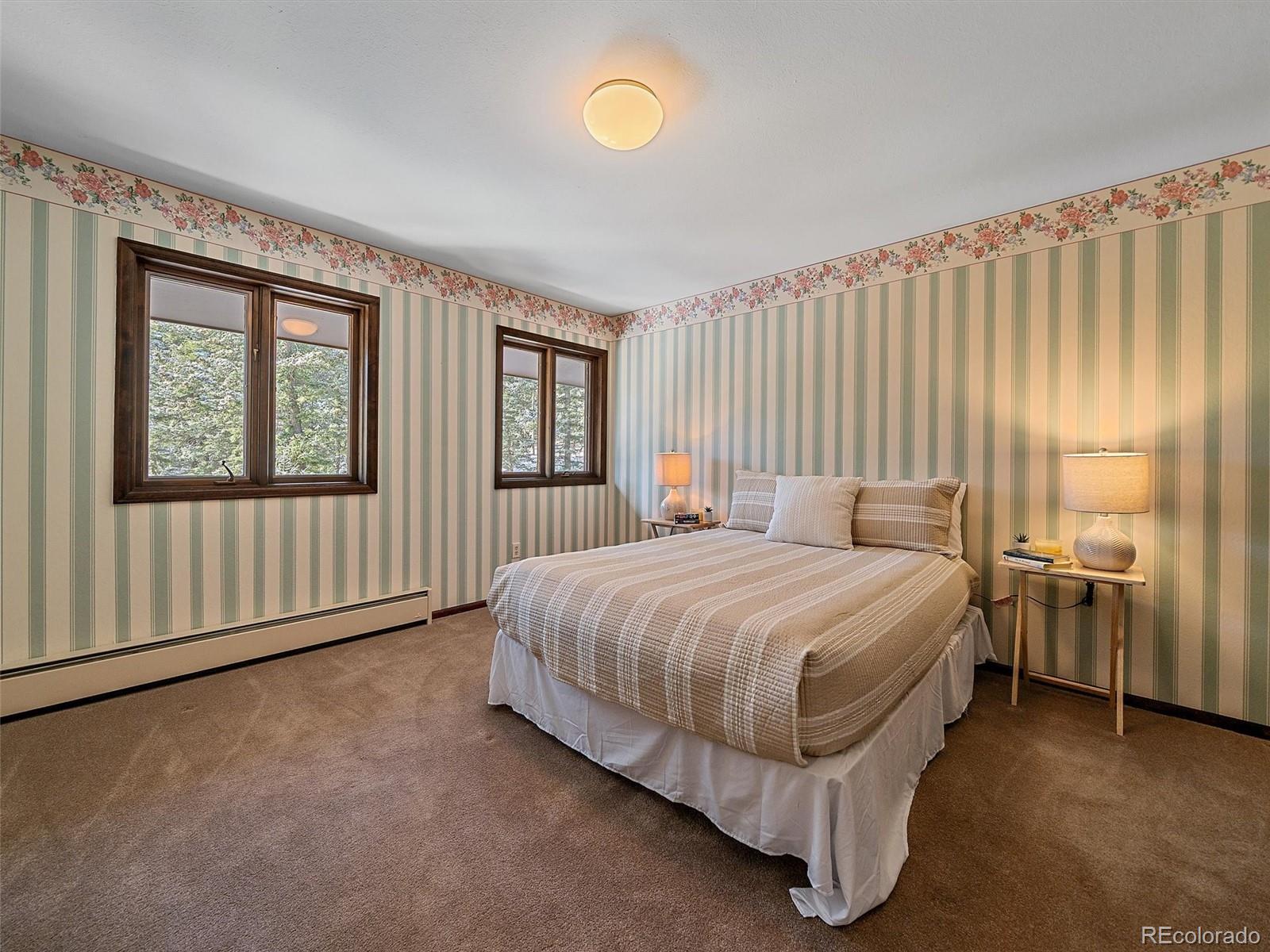 7990 Tim Tam Trail Evergreen, CO 80439 - Photo 29 of 45 a spacious bedroom with a bed and window