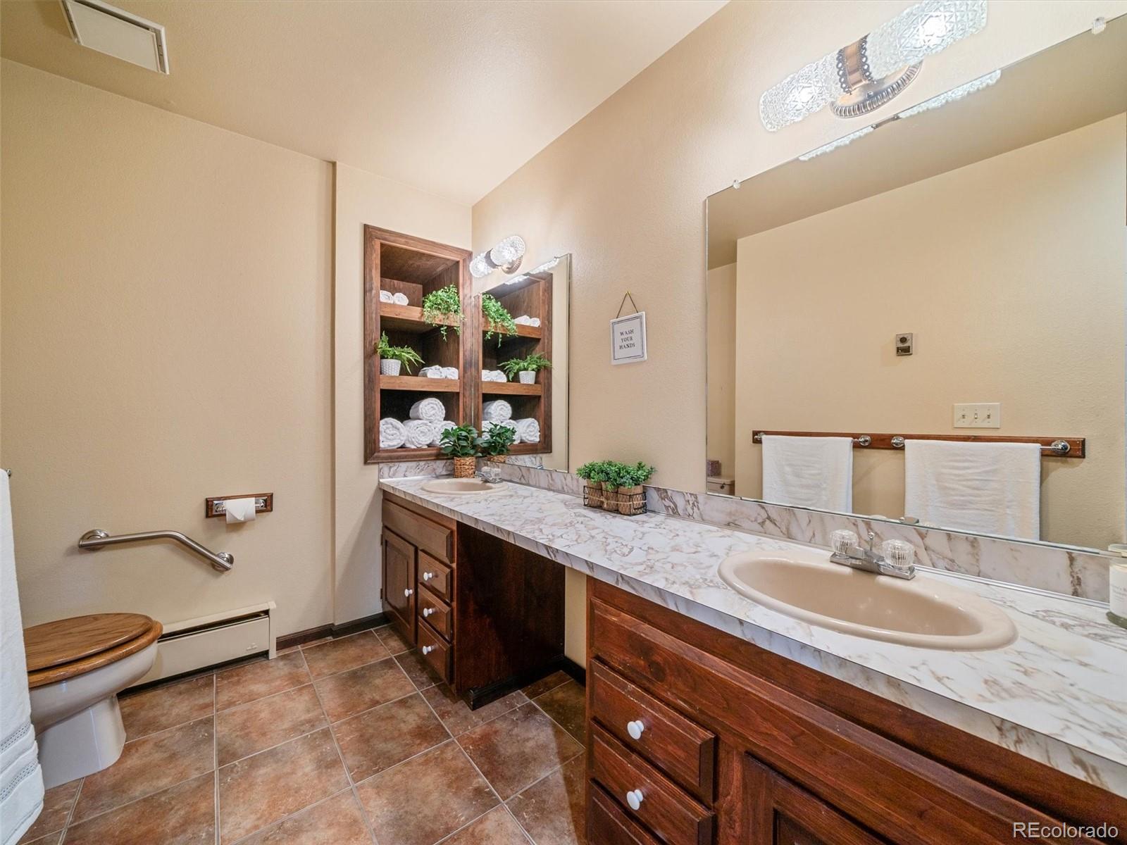 7990 Tim Tam Trail Evergreen, CO 80439 - Photo 30 of 45 a bathroom with a granite countertop sink and a mirror