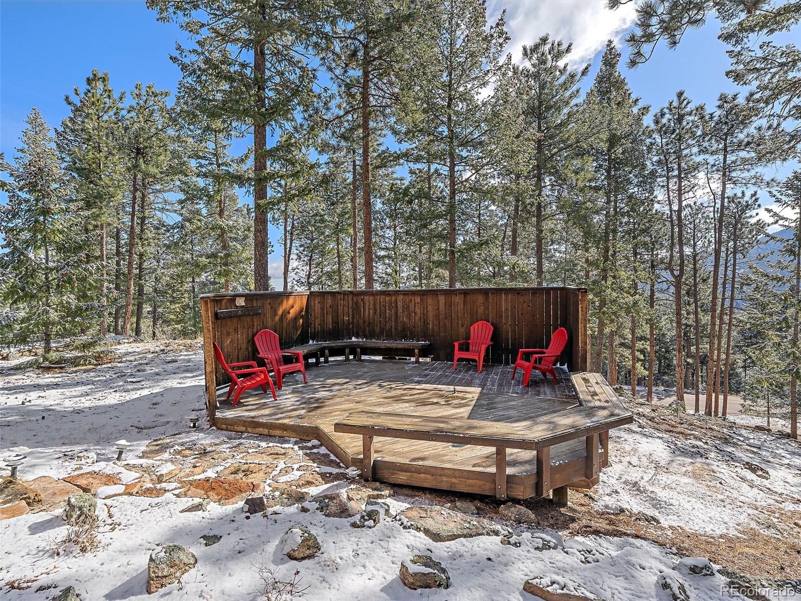 7990 Tim Tam Trail Evergreen, CO 80439 - Photo 37 of 45 a view of a wooden deck with chairs and potted plants