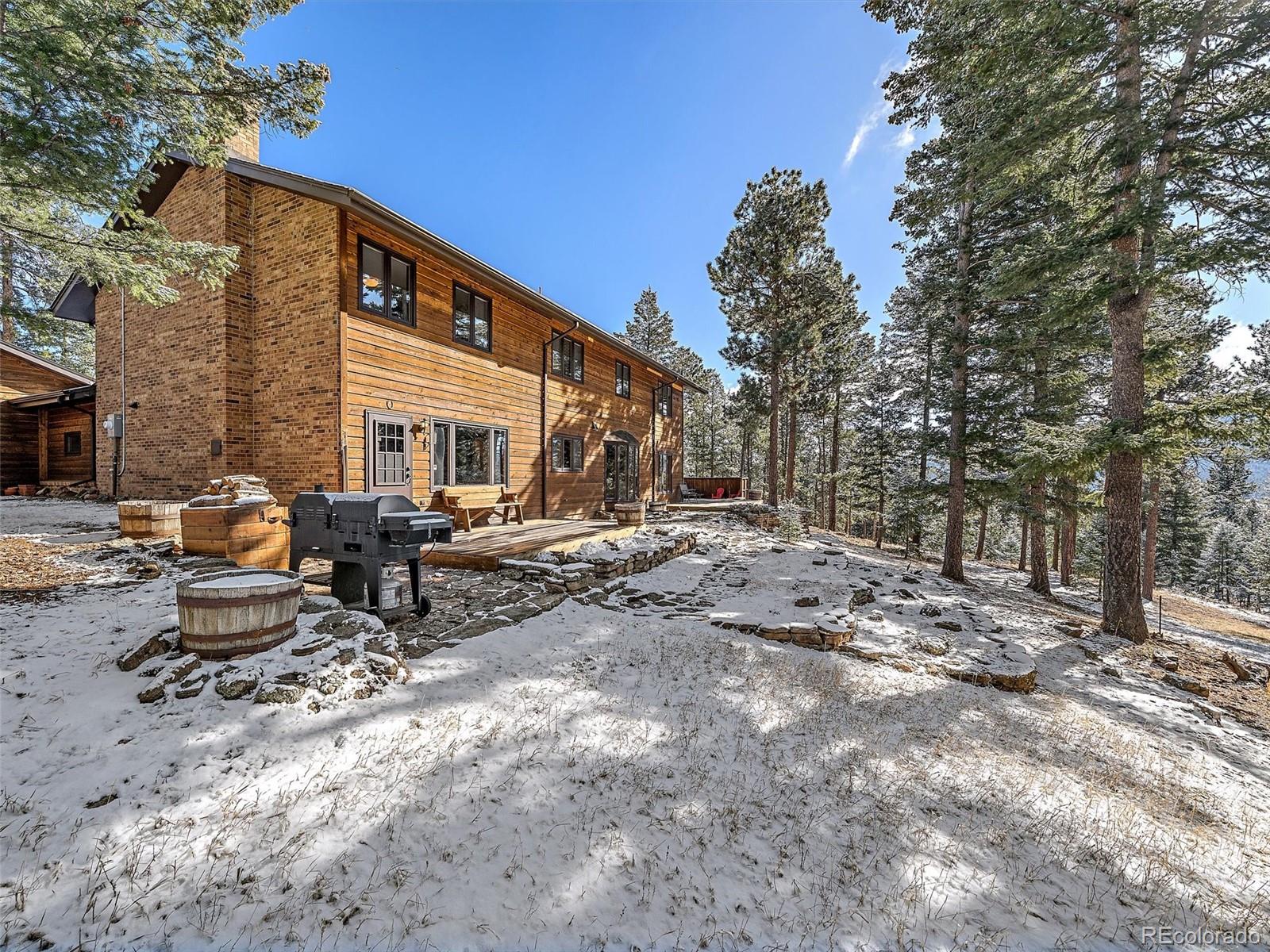 7990 Tim Tam Trail Evergreen, CO 80439 - Photo 40 of 45 a backyard of a house with table and chairs
