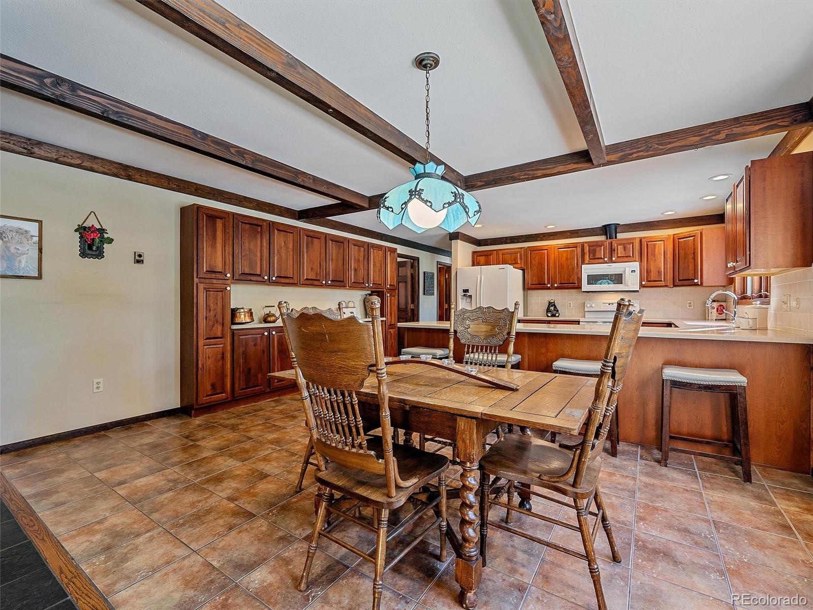 7990 Tim Tam Trail Evergreen, CO 80439 - Photo 10 of 45 a dining room with a wooden table and chairs