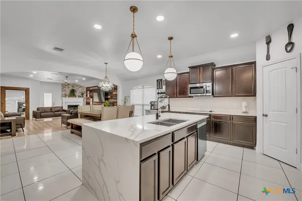 a kitchen with stainless steel appliances kitchen island granite countertop a sink and cabinets