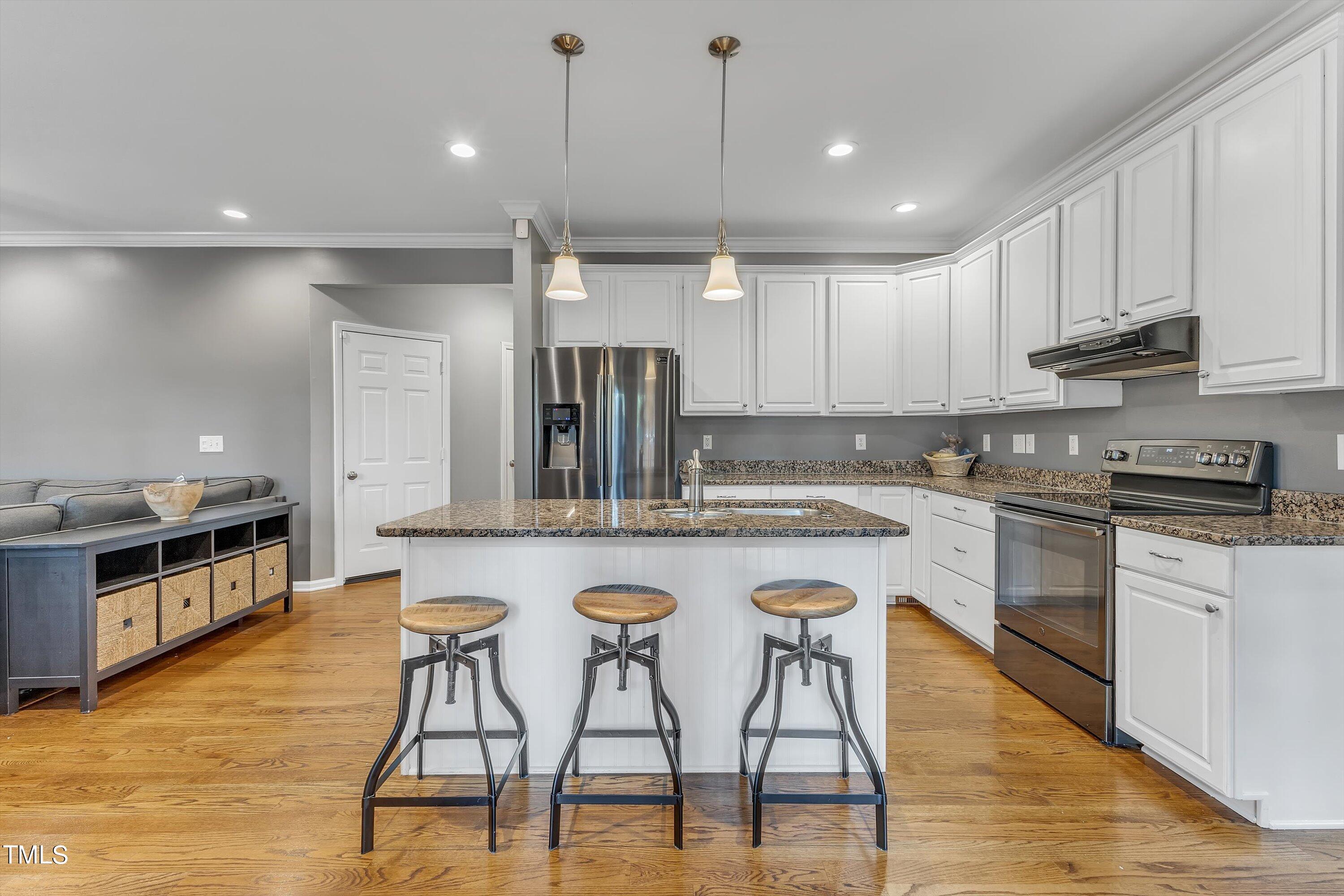 2424 Havershire Drive Raleigh, NC 27613 - Photo 27 of 52 a kitchen with stainless steel appliances granite countertop a stove top oven a sink dishwasher and a refrigerator with wooden floor