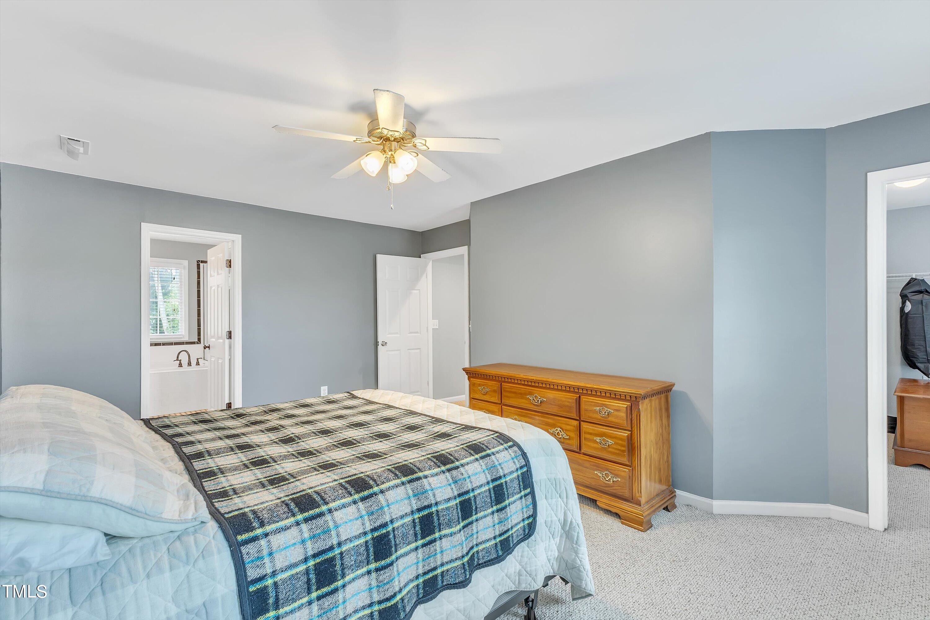 2424 Havershire Drive Raleigh, NC 27613 - Photo 35 of 52 a bedroom with a bed and a chandelier