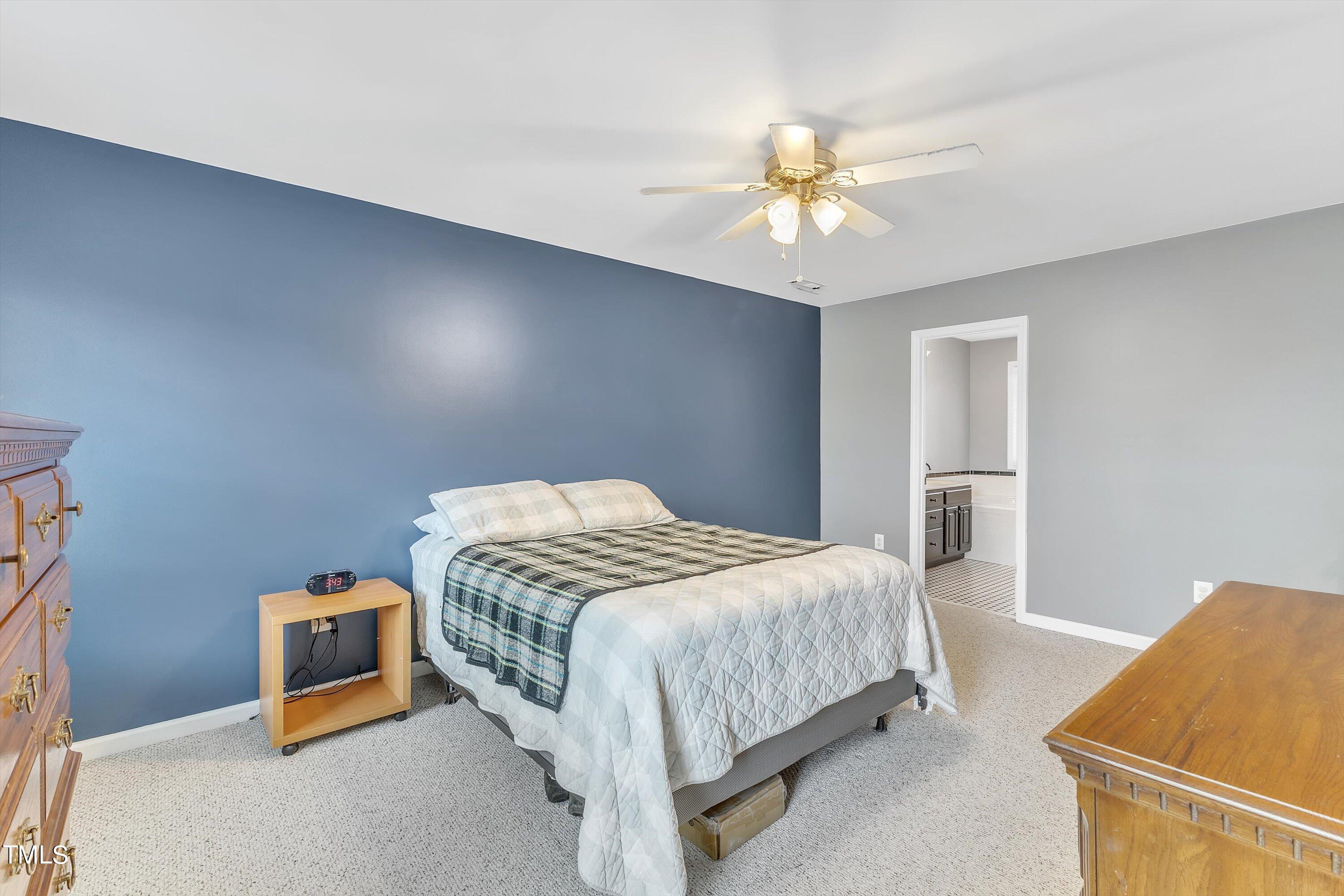2424 Havershire Drive Raleigh, NC 27613 - Photo 36 of 52 a bedroom with a bed and a chandelier