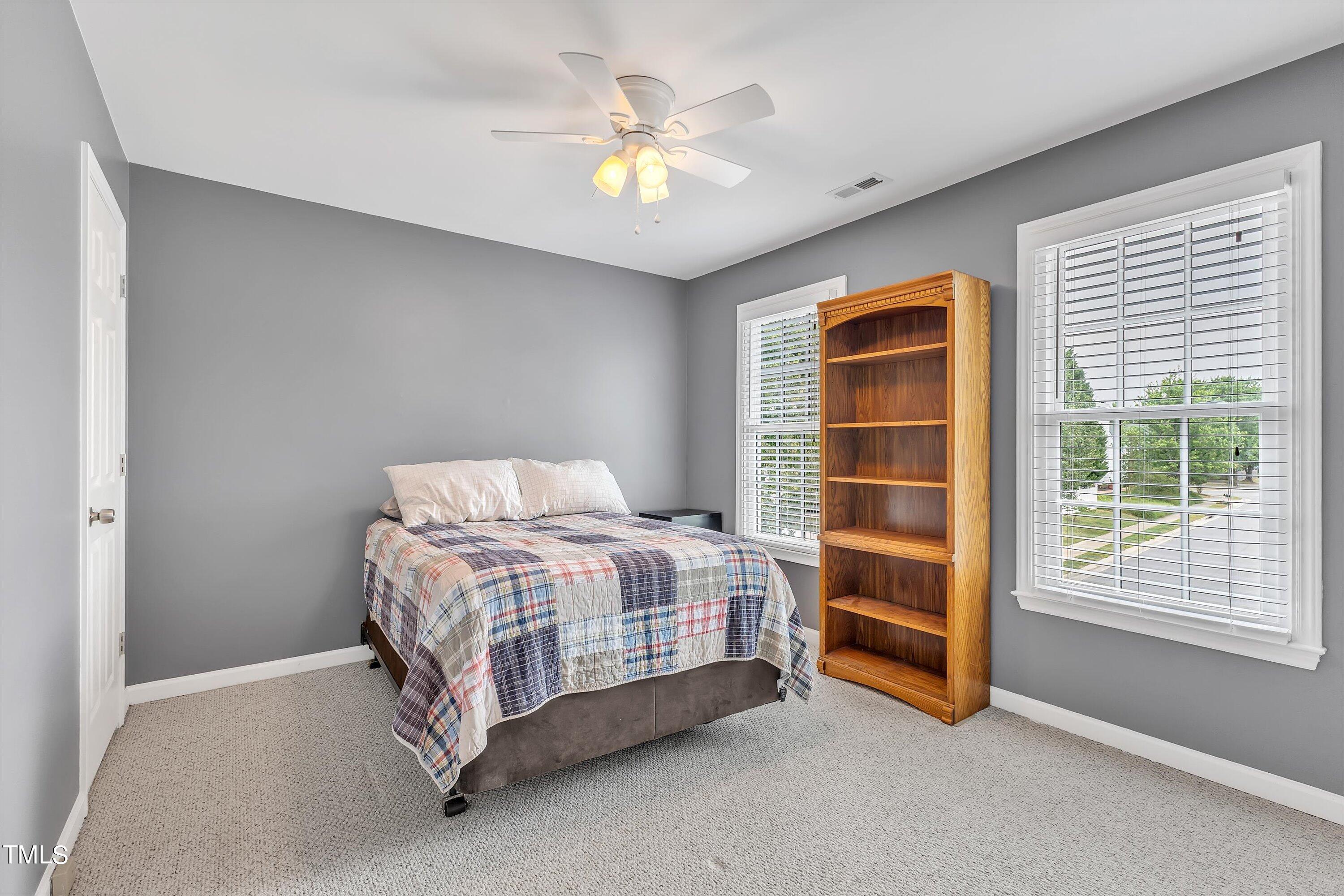 2424 Havershire Drive Raleigh, NC 27613 - Photo 45 of 52 a spacious bedroom with a bed and a ceiling fan