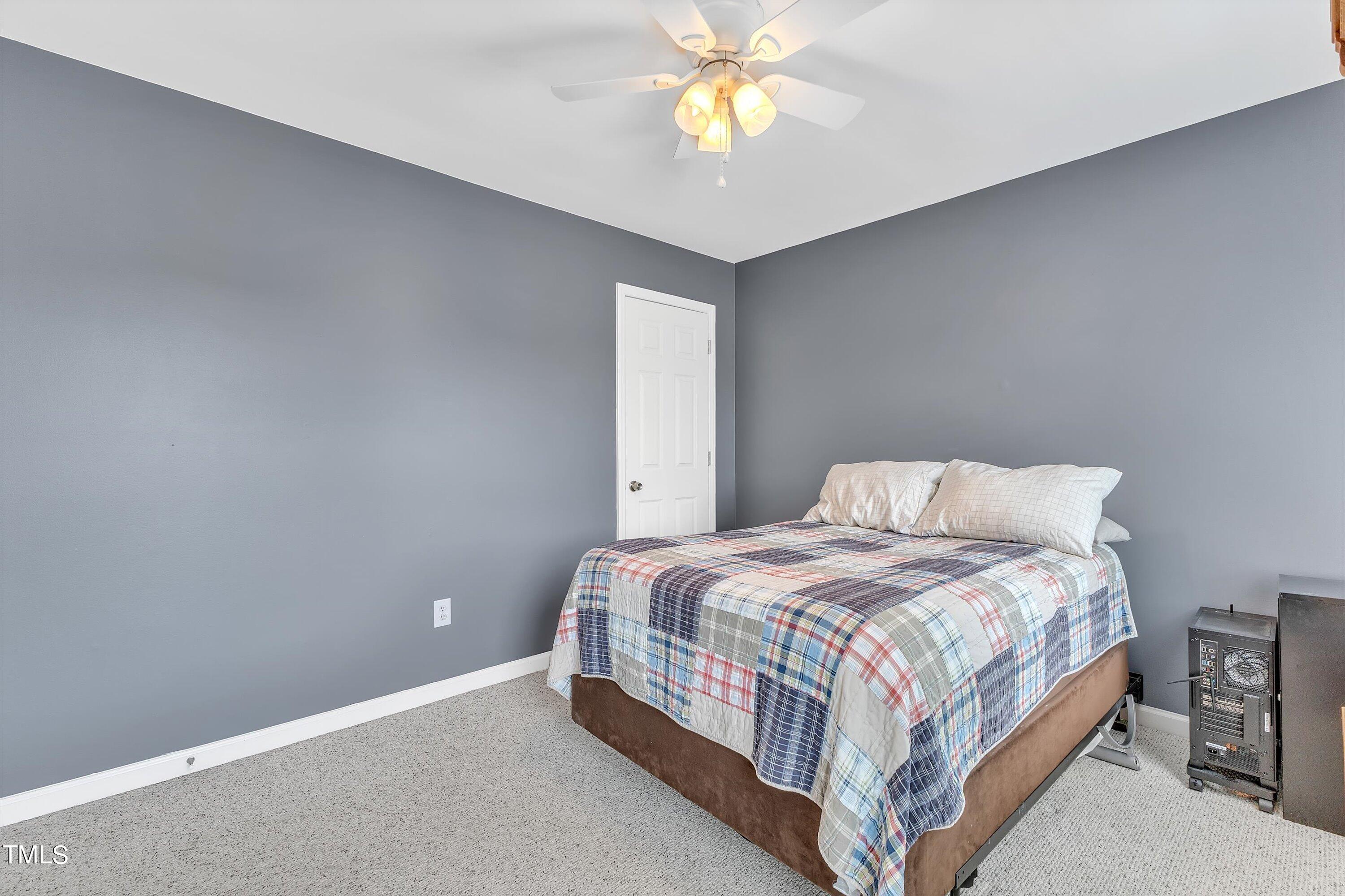 2424 Havershire Drive Raleigh, NC 27613 - Photo 46 of 52 a bedroom with a bed and a chandelier