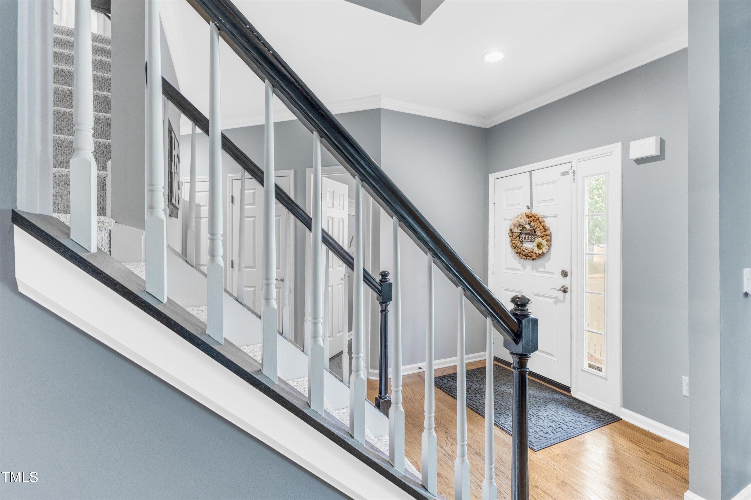 2424 Havershire Drive Raleigh, NC 27613 - Photo 6 of 52 a view of staircase with wooden floor and white walls
