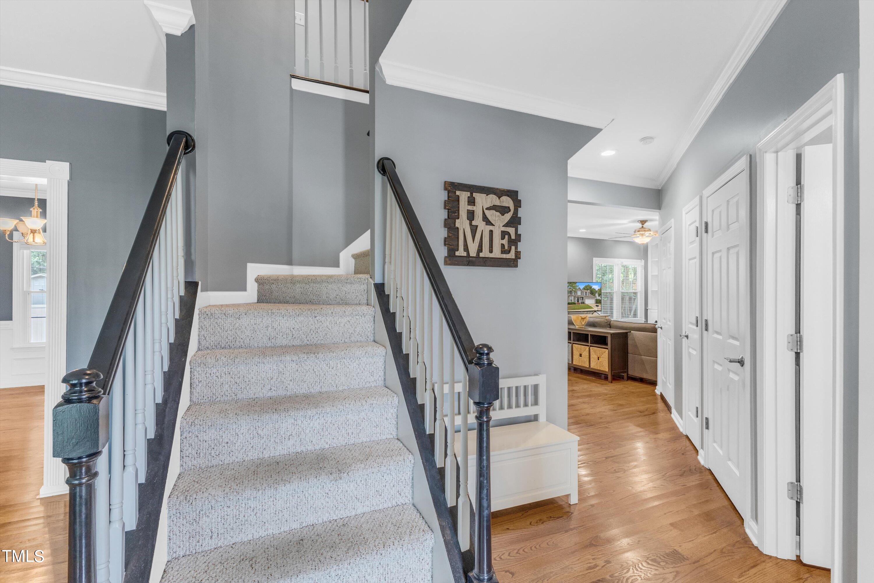 2424 Havershire Drive Raleigh, NC 27613 - Photo 9 of 52 a view of staircase with lots of frames on wall and wooden floor