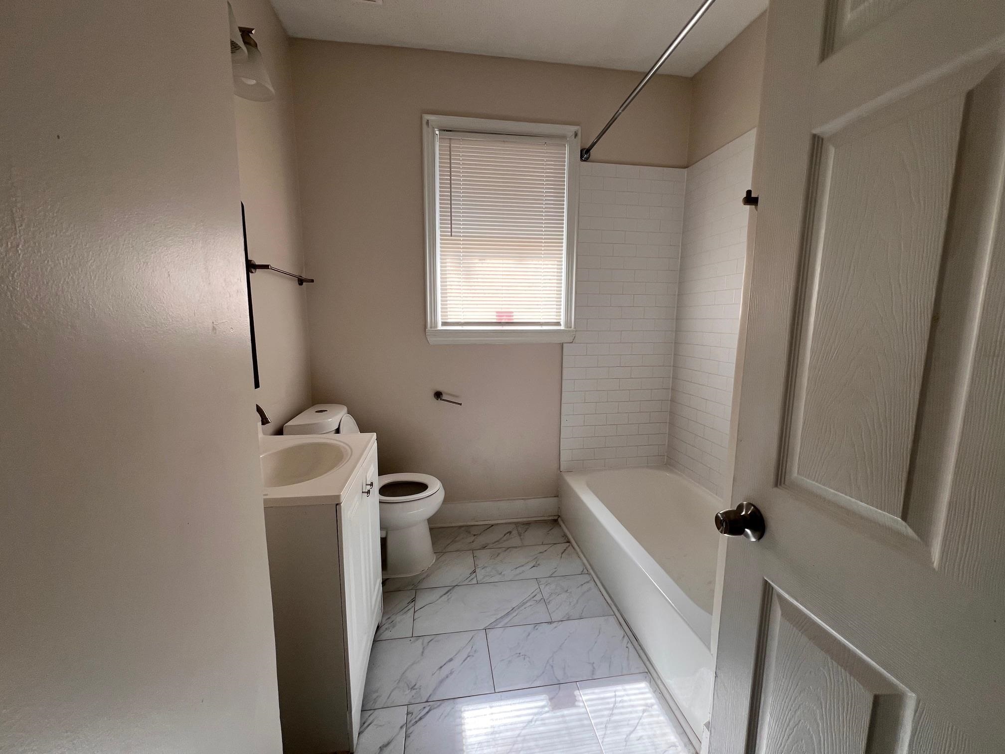 734 Spring Street Memphis, TN 38112 - Photo 11 of 13 a bathroom with a tub a toilet and a shower