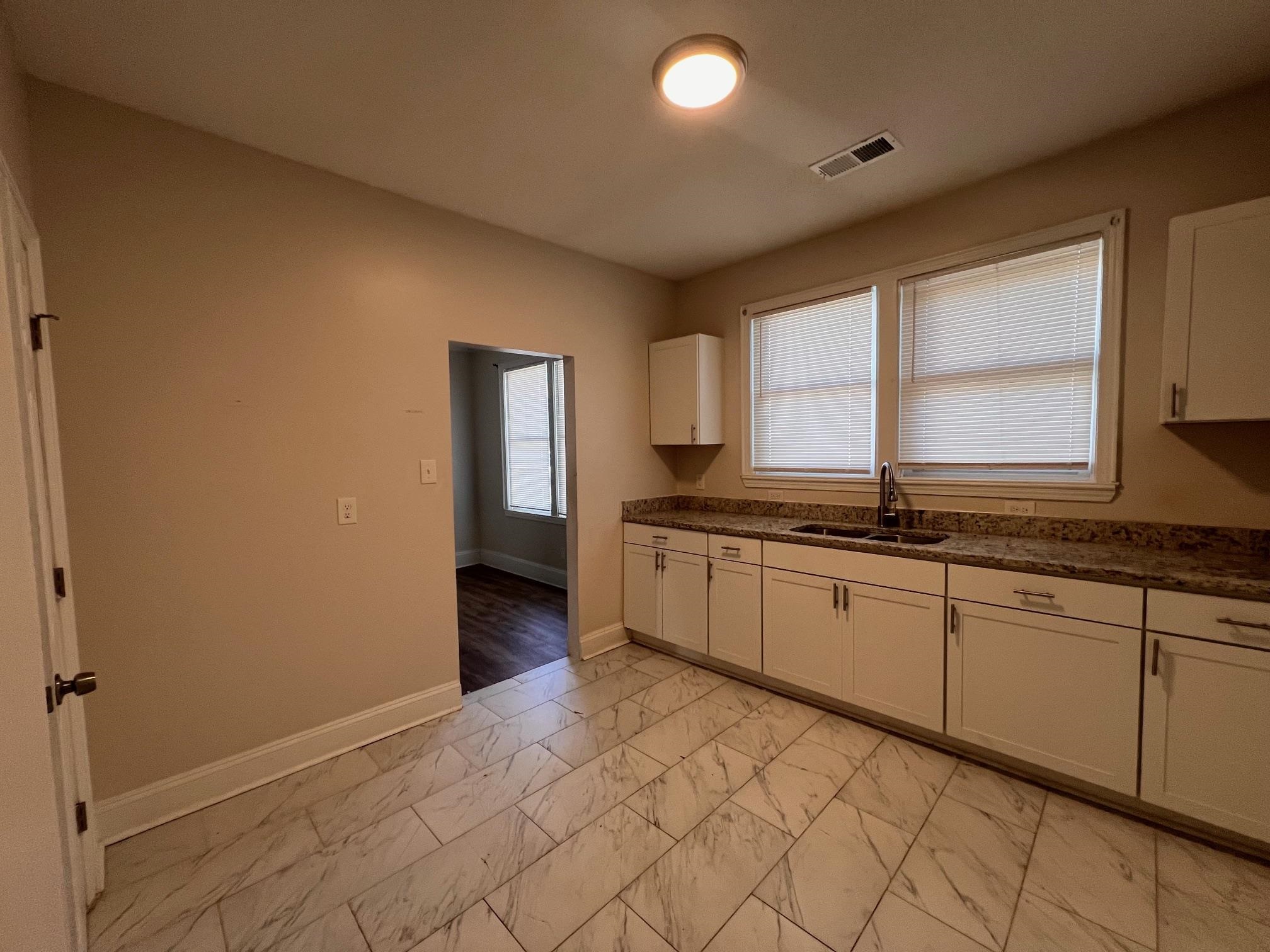 734 Spring Street Memphis, TN 38112 - Photo 4 of 13 a large kitchen with a sink and cabinets
