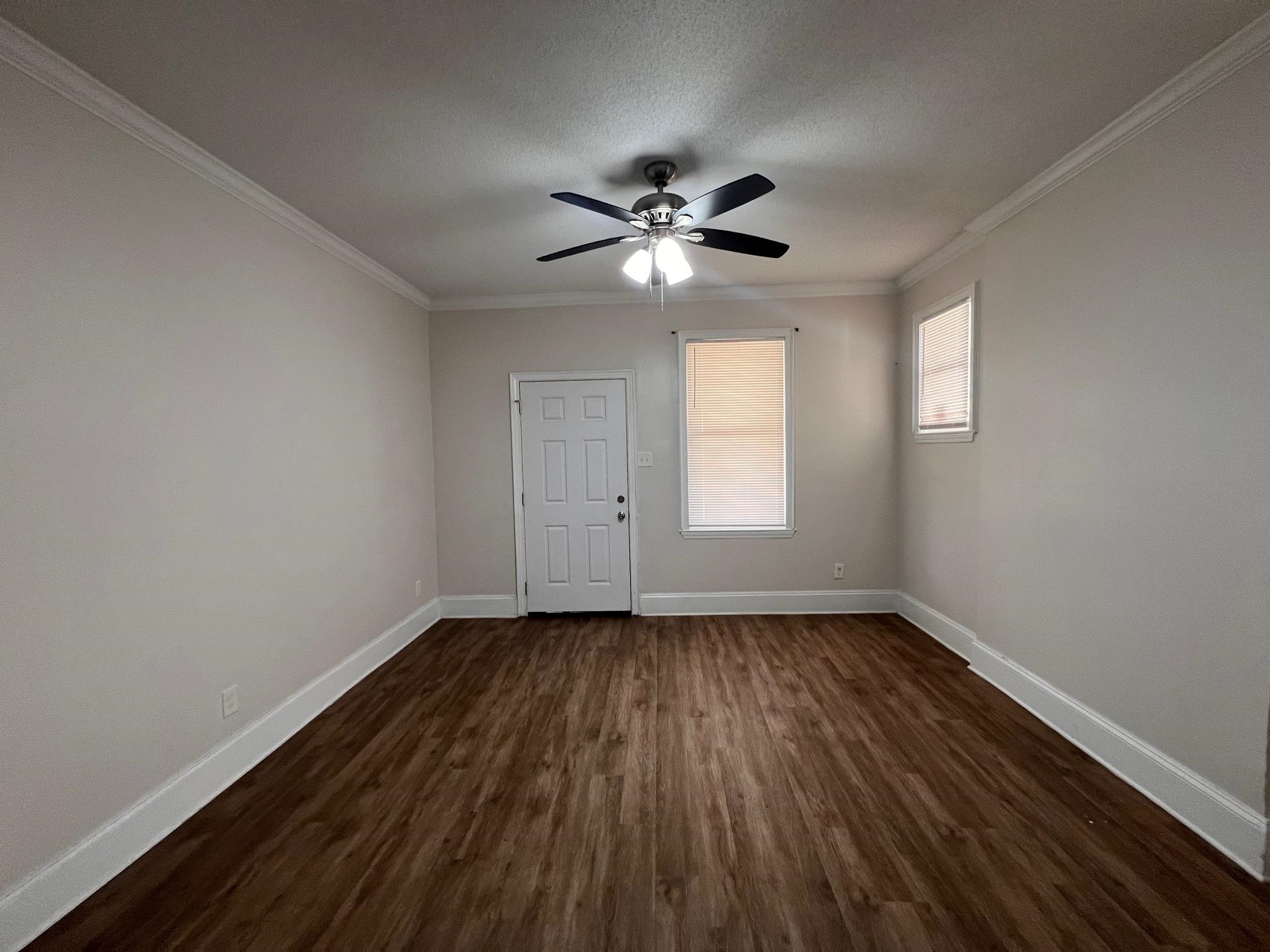 734 Spring Street Memphis, TN 38112 - Photo 6 of 13 a view of empty room with wooden floor and fan