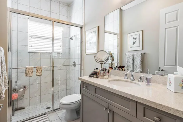 a bathroom with a granite countertop toilet sink and a shower