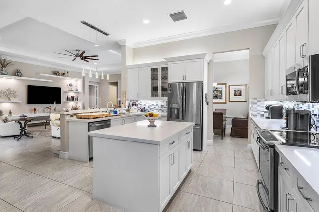 a kitchen with stainless steel appliances a refrigerator sink and white cabinets